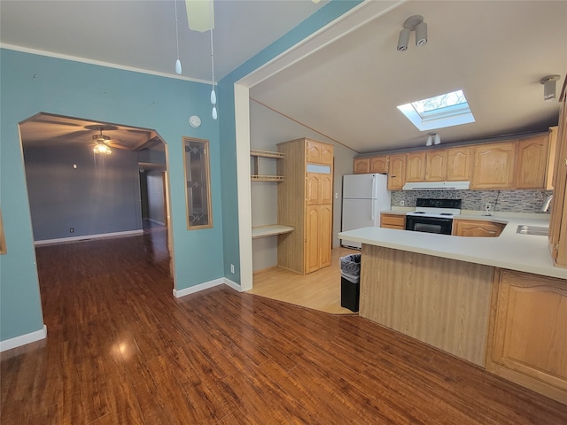 kitchen featuring hardwood / wood-style floors, kitchen peninsula, ceiling fan, vaulted ceiling with skylight, and white appliances