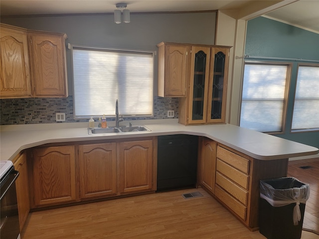 kitchen featuring tasteful backsplash, kitchen peninsula, sink, and light hardwood / wood-style floors