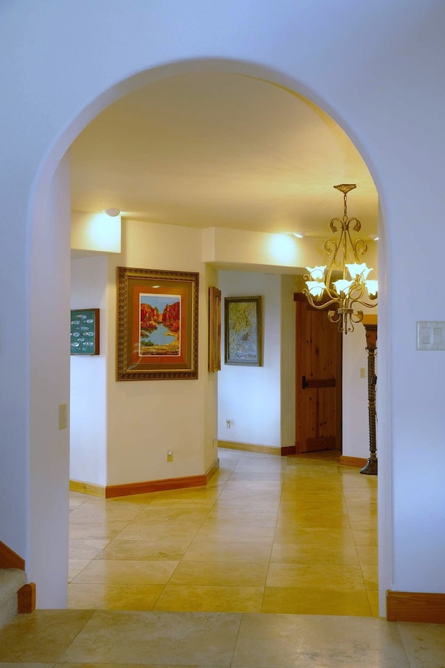 hall featuring an inviting chandelier and light tile patterned floors