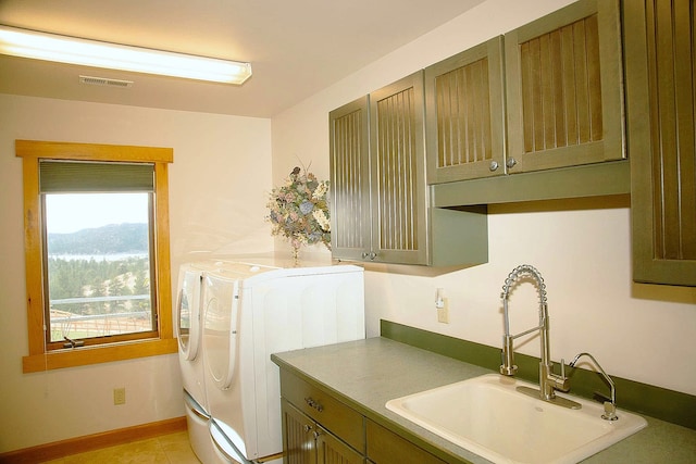 clothes washing area with cabinets, a mountain view, washer and clothes dryer, and sink