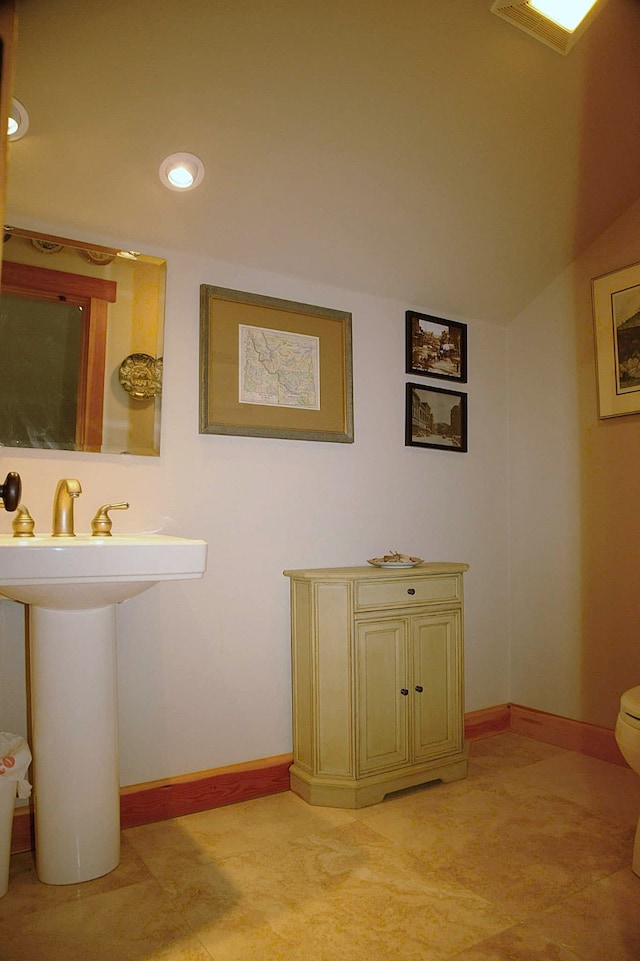 bathroom featuring vaulted ceiling, toilet, and sink