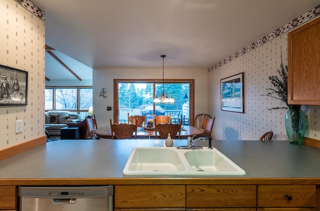 kitchen featuring stainless steel dishwasher, hanging light fixtures, sink, and a notable chandelier