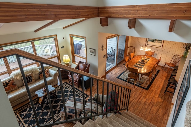 staircase with lofted ceiling with beams and wood-type flooring