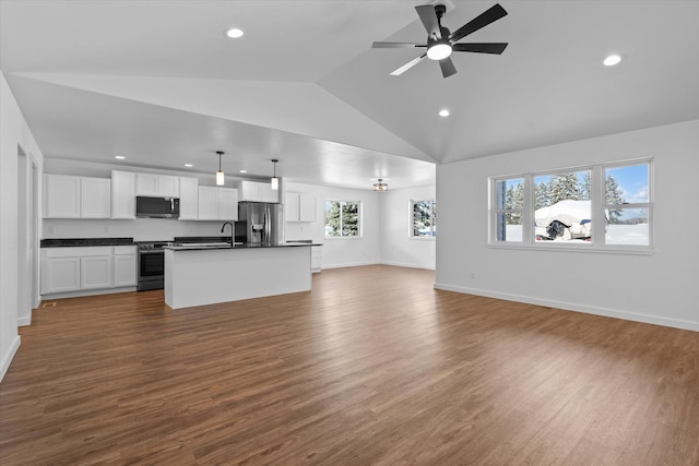 unfurnished living room with sink, ceiling fan, dark wood-type flooring, and vaulted ceiling