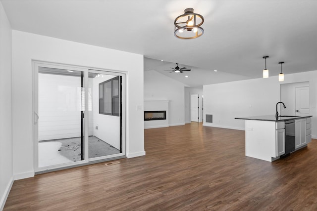 kitchen with hanging light fixtures, dark wood-type flooring, ceiling fan, sink, and white cabinetry