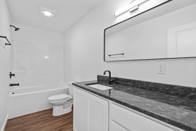 full bathroom with hardwood / wood-style flooring, shower / tub combination, vanity, and toilet