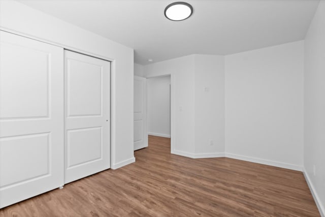 unfurnished bedroom with light hardwood / wood-style floors and a closet