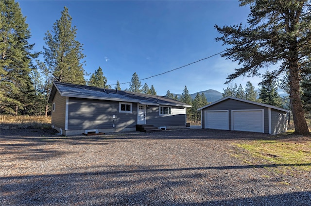 single story home featuring an outbuilding and a garage