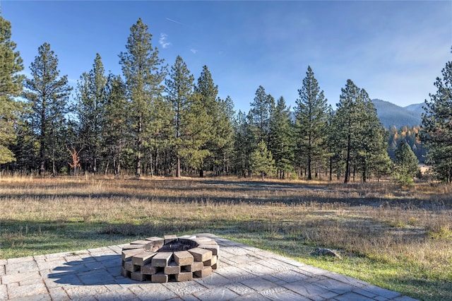 view of patio / terrace with a mountain view and an outdoor fire pit