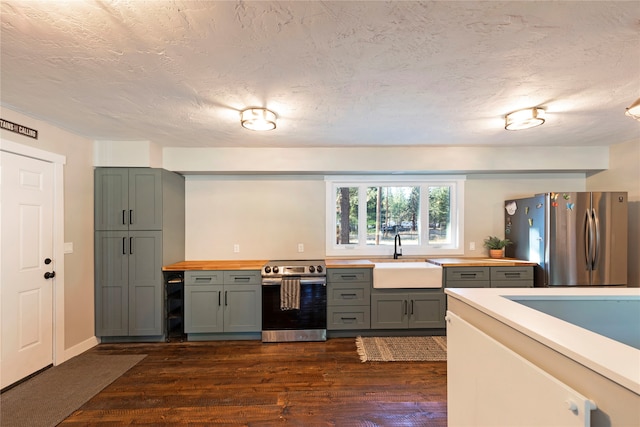 kitchen featuring wood counters, sink, dark hardwood / wood-style flooring, and appliances with stainless steel finishes