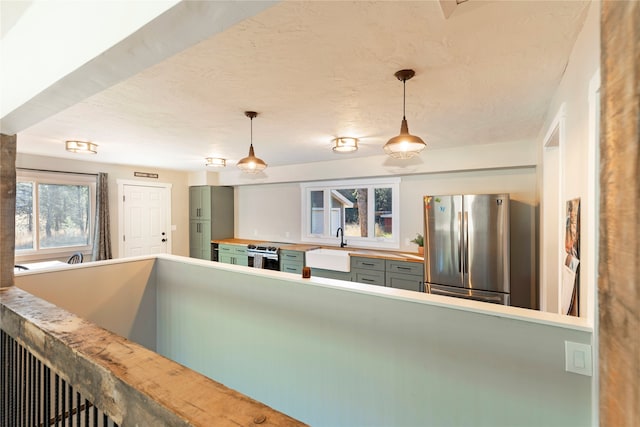 kitchen with stainless steel appliances, sink, and hanging light fixtures