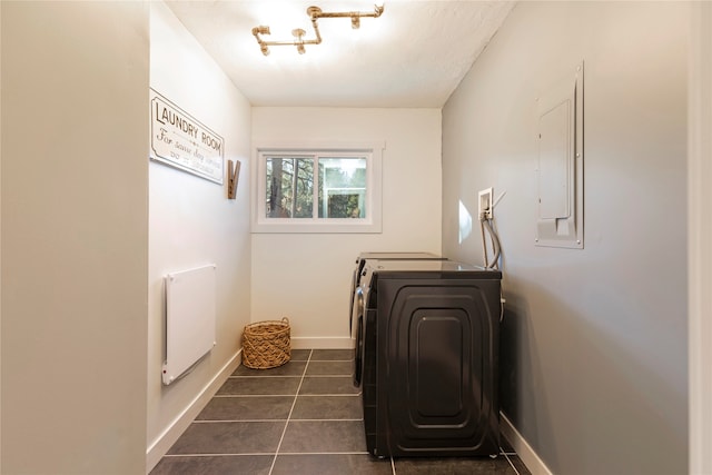 laundry area featuring dark tile patterned flooring, washer and clothes dryer, and electric panel