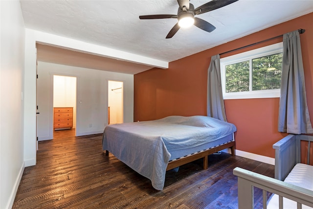 bedroom with ceiling fan, dark wood-type flooring, and a textured ceiling