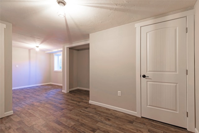 interior space featuring dark wood-type flooring and a textured ceiling