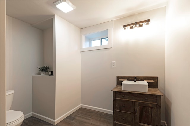 bathroom with hardwood / wood-style flooring, vanity, and toilet