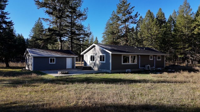 exterior space with a garage, an outbuilding, and a patio area