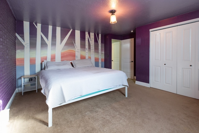 bedroom with carpet flooring, brick wall, and a closet