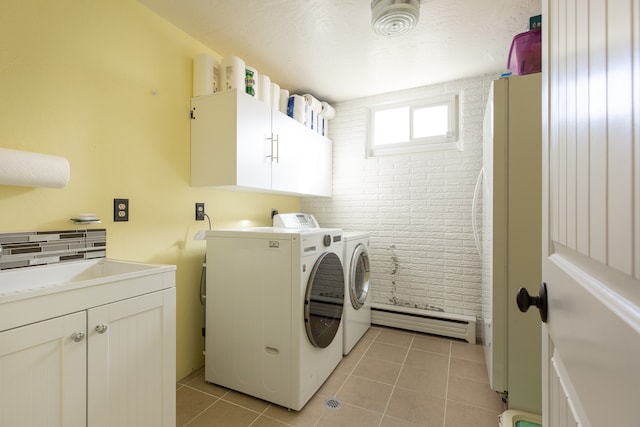 clothes washing area with cabinets, baseboard heating, sink, light tile patterned floors, and washing machine and clothes dryer