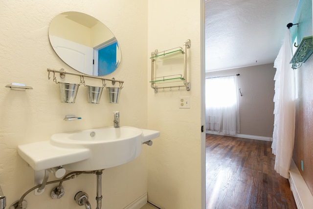 bathroom featuring hardwood / wood-style floors and a textured ceiling