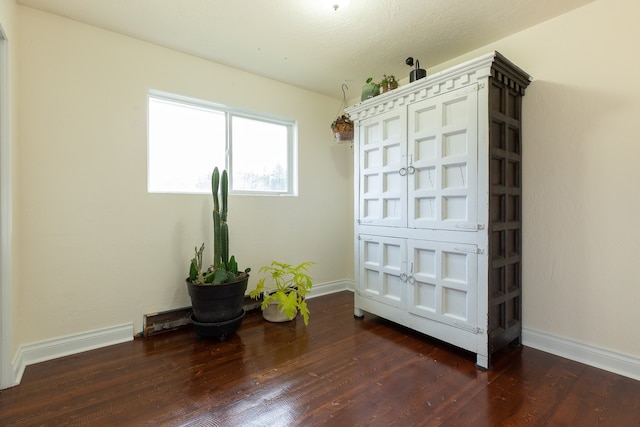 spare room featuring dark hardwood / wood-style flooring and a textured ceiling