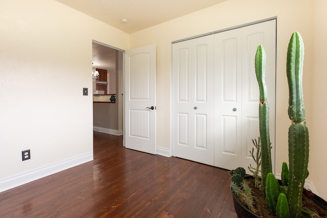 unfurnished bedroom with dark hardwood / wood-style floors and a closet