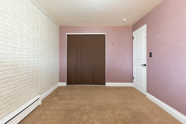 unfurnished bedroom featuring a closet, carpet floors, a textured ceiling, and a baseboard radiator