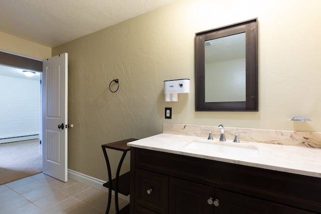 bathroom with tile patterned flooring, vanity, a textured ceiling, and a baseboard radiator