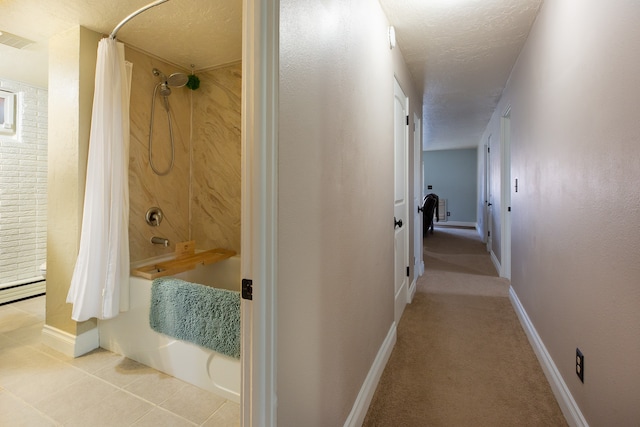 interior space with tile patterned flooring, shower / bath combination with curtain, and a textured ceiling