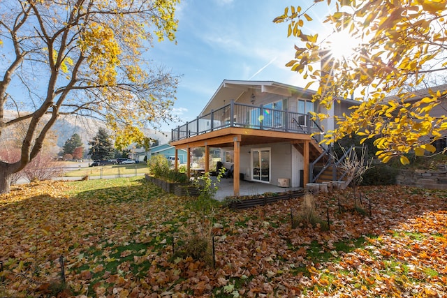 rear view of house featuring a patio area and a wooden deck