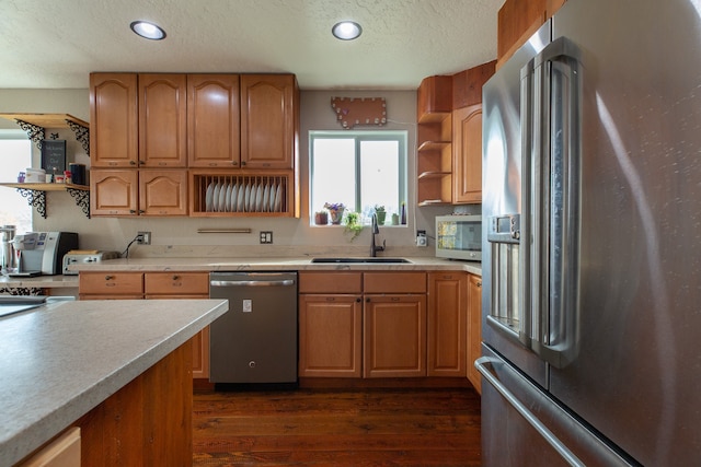 kitchen featuring appliances with stainless steel finishes, dark hardwood / wood-style flooring, a textured ceiling, and sink