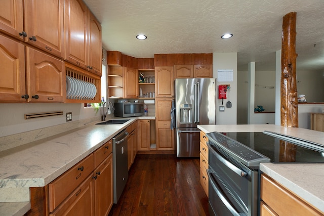 kitchen with sink, dark hardwood / wood-style flooring, stainless steel appliances, and a textured ceiling