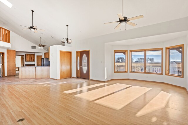 451 1st Rd NE, Fairfield, MT 59436 - unfurnished living room featuring high vaulted ceiling, ceiling fan, and light wood-style flooring