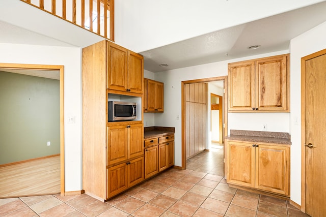 451 1st Rd NE, Fairfield, MT 59436 - kitchen featuring stainless steel microwave, light tile patterned flooring, and dark countertops