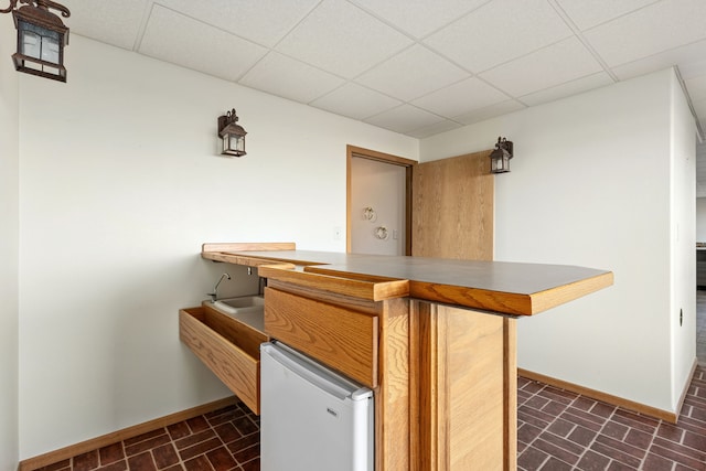 451 1st Rd NE, Fairfield, MT 59436 - indoor bar featuring a paneled ceiling, fridge, and brick patterned flooring