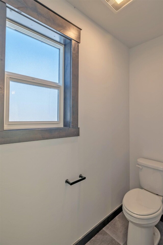 bathroom featuring toilet, tile patterned flooring, and plenty of natural light