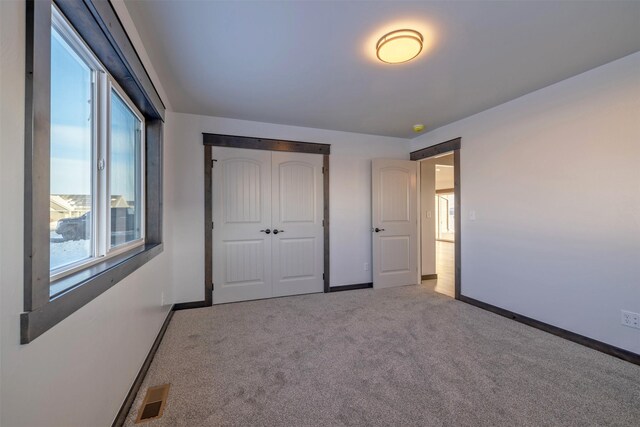 unfurnished bedroom featuring carpet floors and a closet