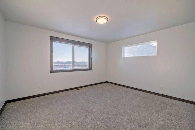 carpeted spare room featuring plenty of natural light