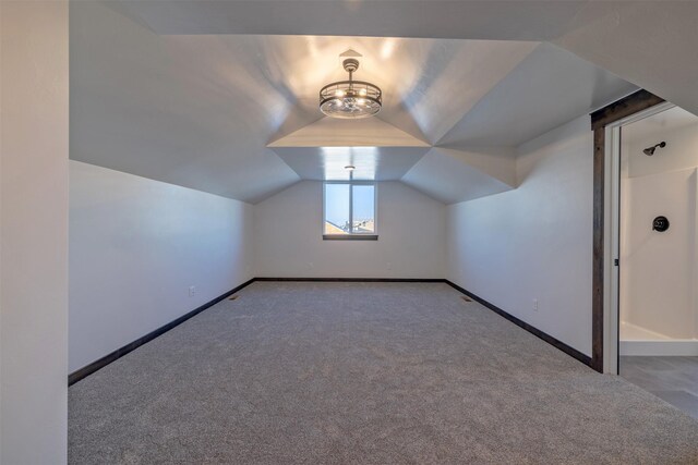 additional living space featuring lofted ceiling and light colored carpet