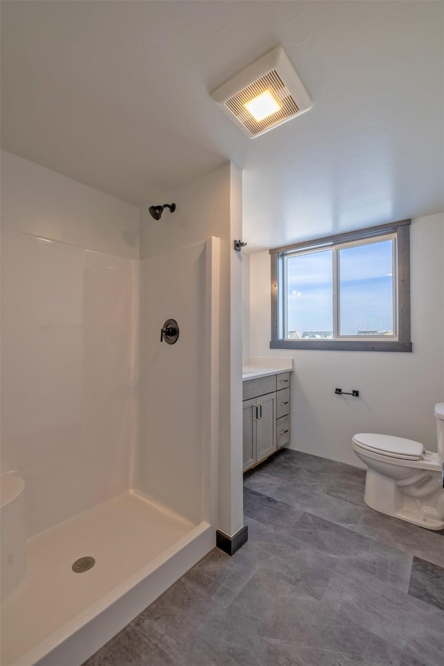 bathroom featuring toilet, walk in shower, and vanity