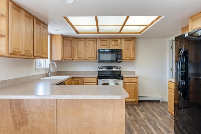 kitchen with black appliances, kitchen peninsula, hardwood / wood-style floors, and a baseboard heating unit