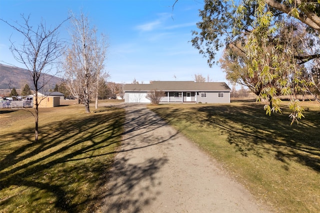 view of front facade featuring a mountain view, a front yard, and a garage