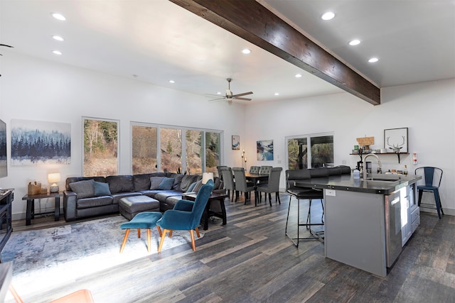 living room with beamed ceiling, sink, ceiling fan, a towering ceiling, and dark hardwood / wood-style flooring