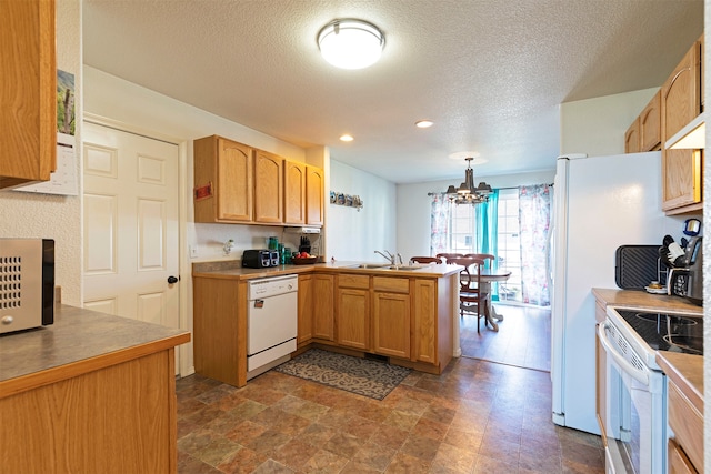 kitchen with white appliances, decorative light fixtures, an inviting chandelier, sink, and kitchen peninsula