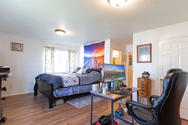 bedroom with wood-type flooring and a textured ceiling