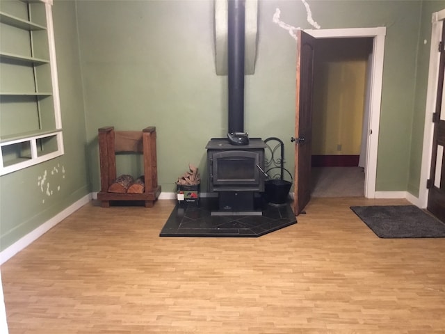 living room featuring light hardwood / wood-style floors and a wood stove