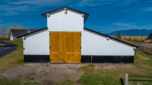 view of home's exterior with a mountain view and an outdoor structure