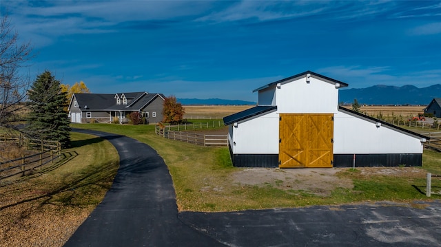 view of side of property with a mountain view and an outdoor structure