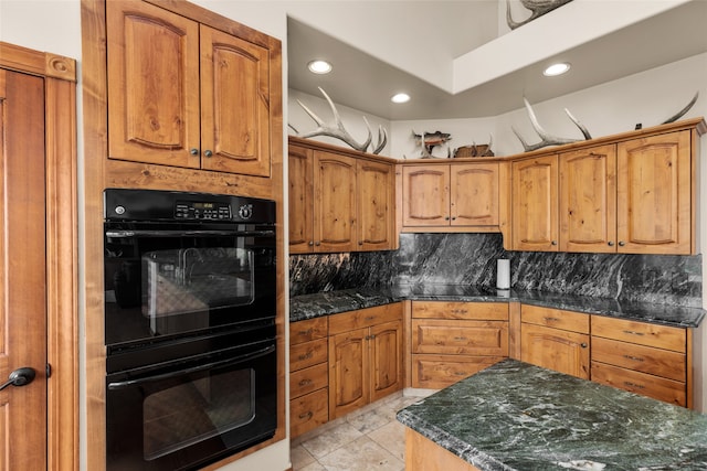 kitchen featuring black appliances, tasteful backsplash, dark stone countertops, and light tile patterned floors