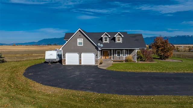 view of front of home with a mountain view, a front lawn, and covered porch