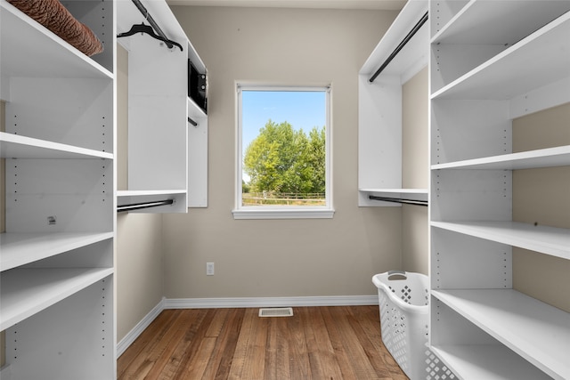 walk in closet with hardwood / wood-style floors